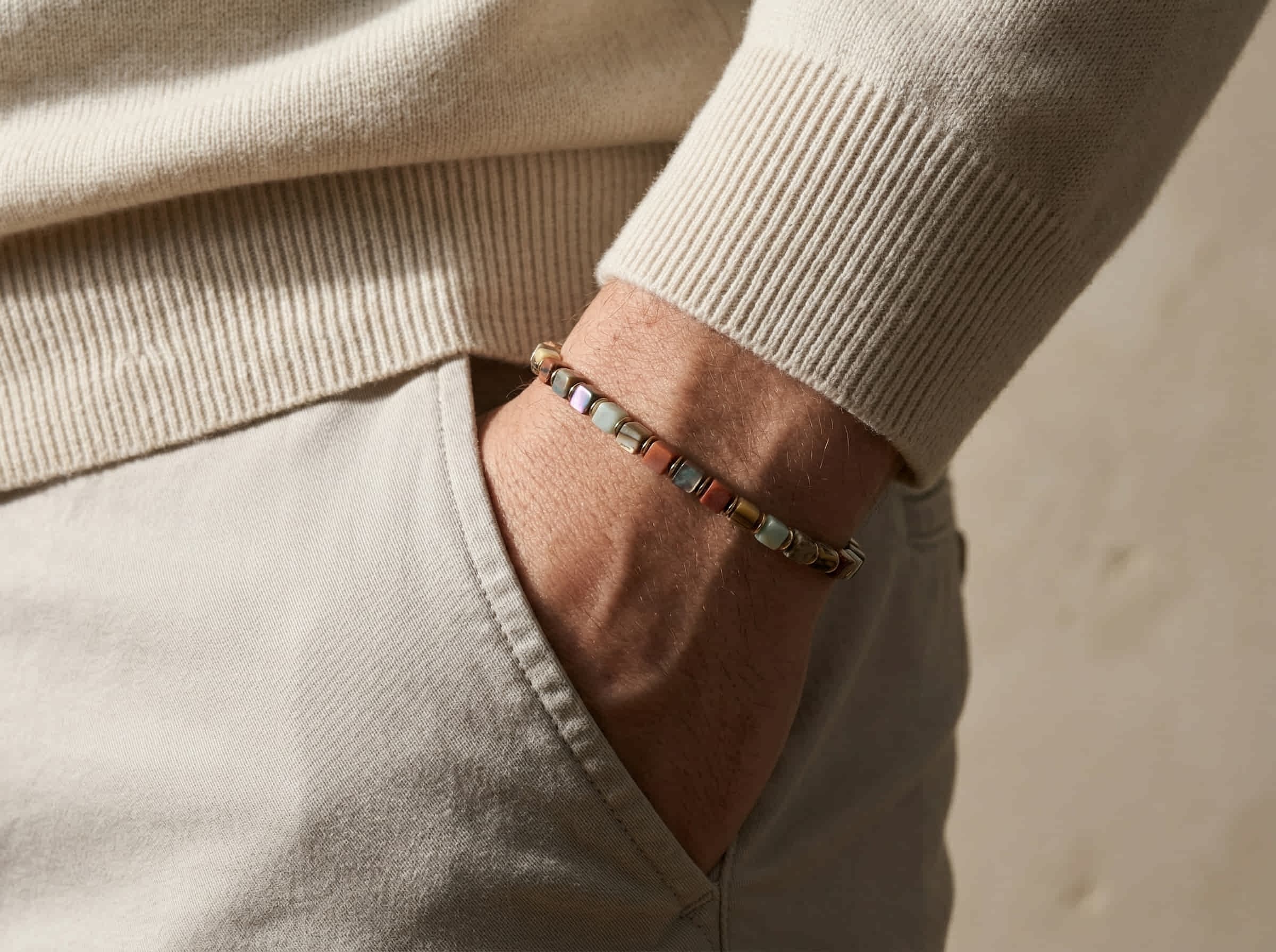 Polsfoto man met beige pullover en armband handgemaakt van abalone en imperial jaspis stenen 4mm