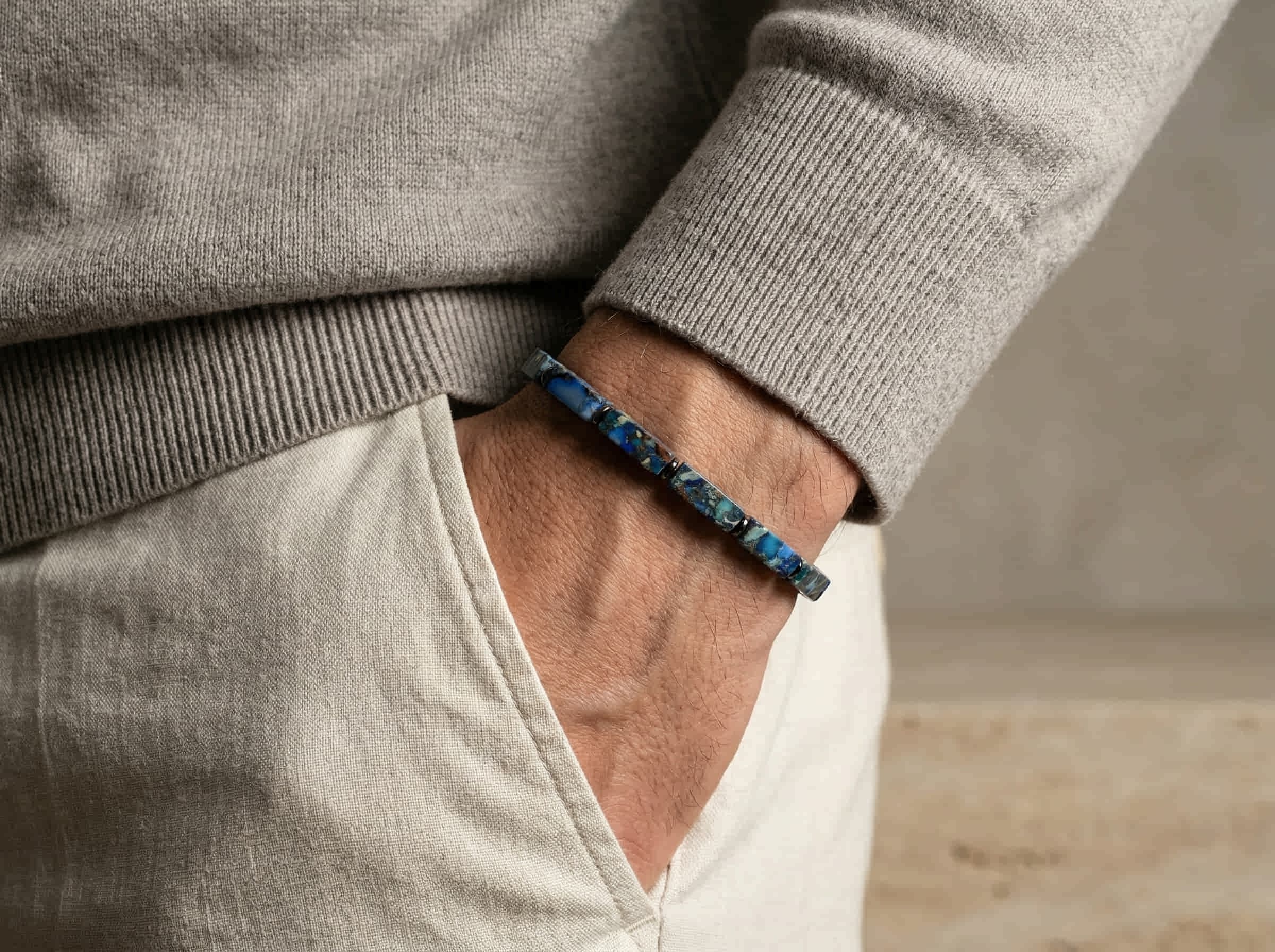 Polsfoto man met grijze pullover en armband handgemaakt van blauwe imperial jasper kubus stenen 4mm