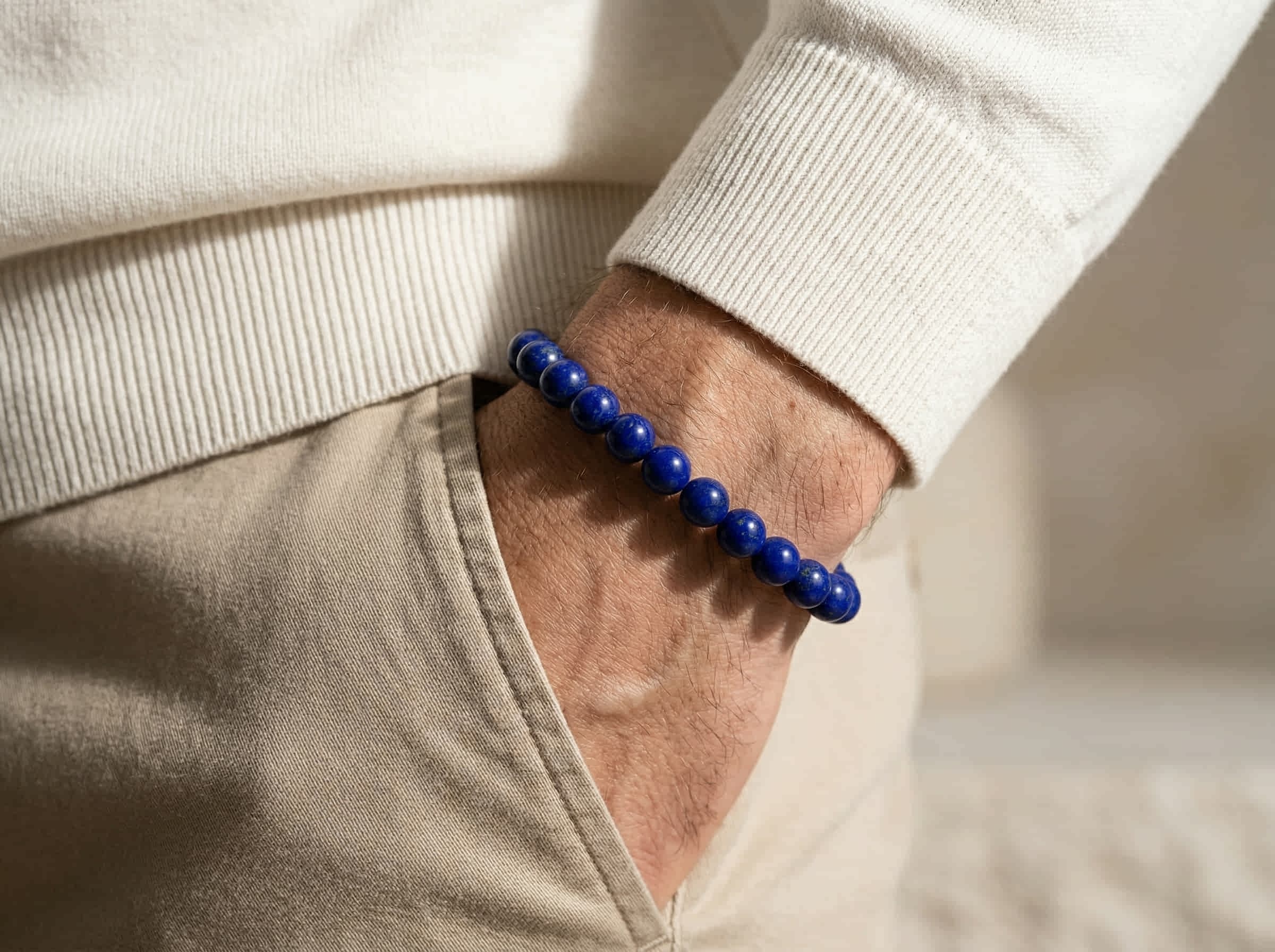 Polsfoto man met witte pullover en armband handgemaakt van blauwe lapis lazulli stenen in 10mm