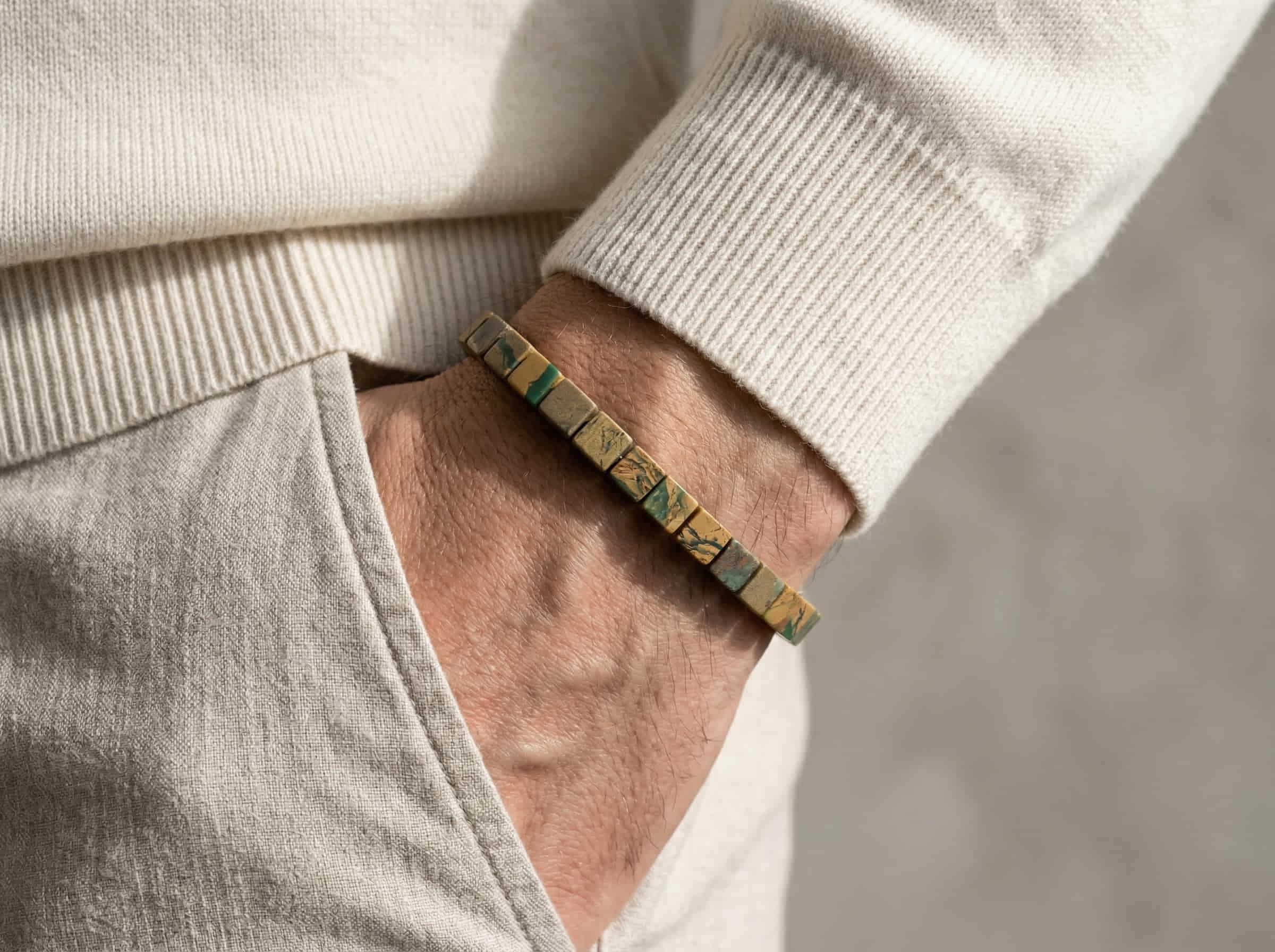 Polsfoto man met witte pullover en armband handgemaakt van groene platte kubus verdiet stenen in 6mm