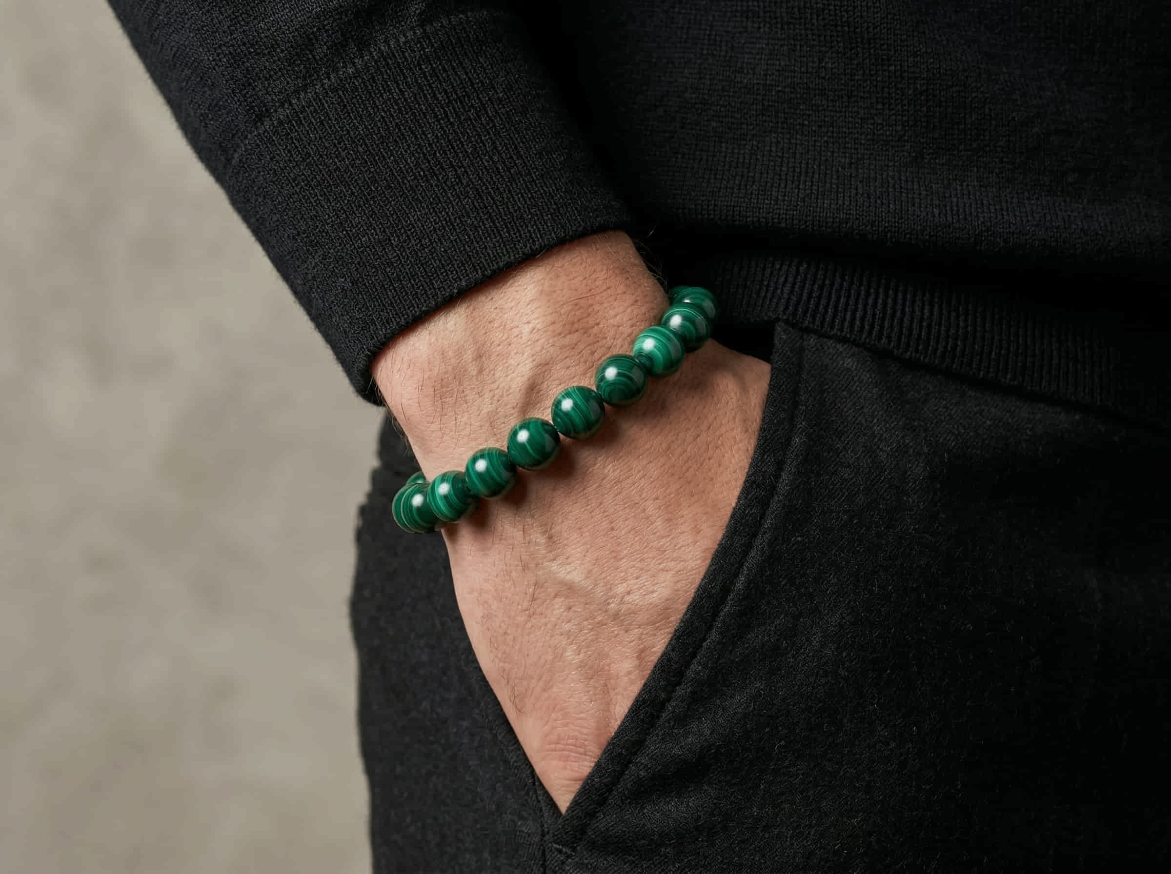 Polsfoto van man met zwarte pullover en armband handgemaakt van groene malachiet stenen in 10mm
